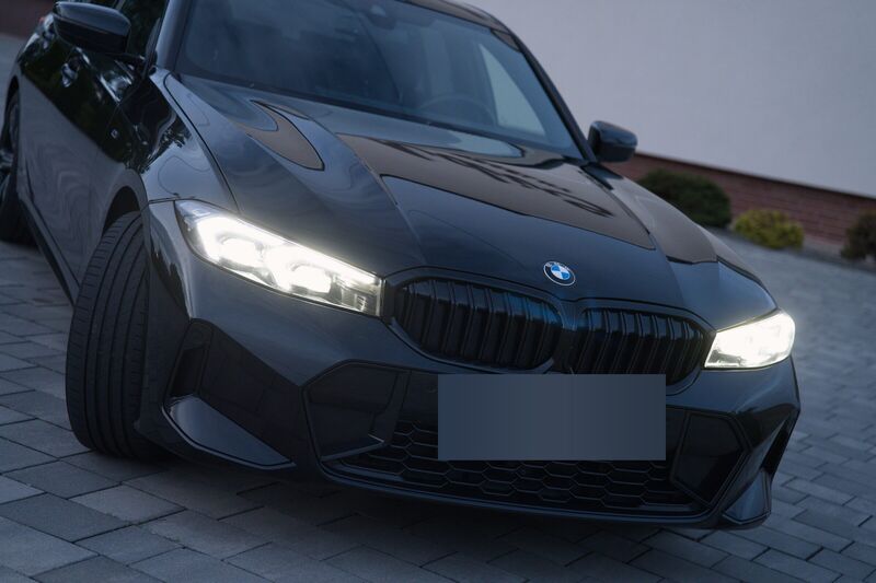 Atrapa chłodnicy i włączone reflektory sedana BMW