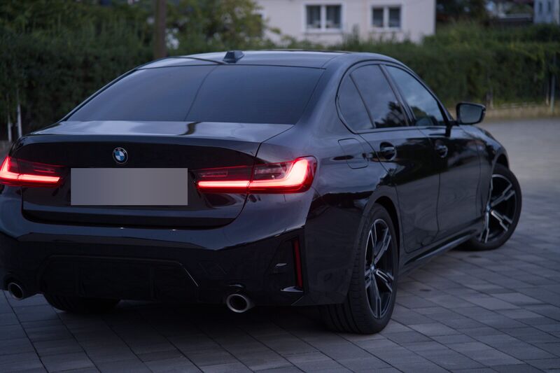 Ciemny sedan BMW widziany z tyłu od prawej strony