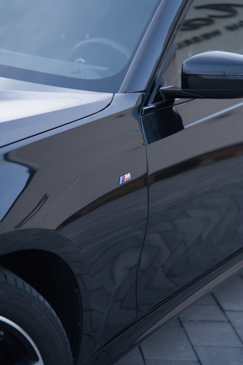 Przedni błotnik, koło i lusterko sedana BMW
