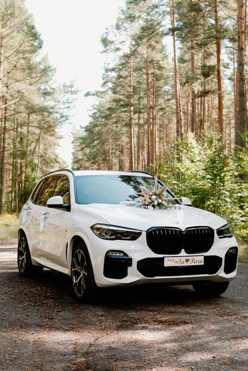 Białe BMW X5 do ślubu wśród sosen